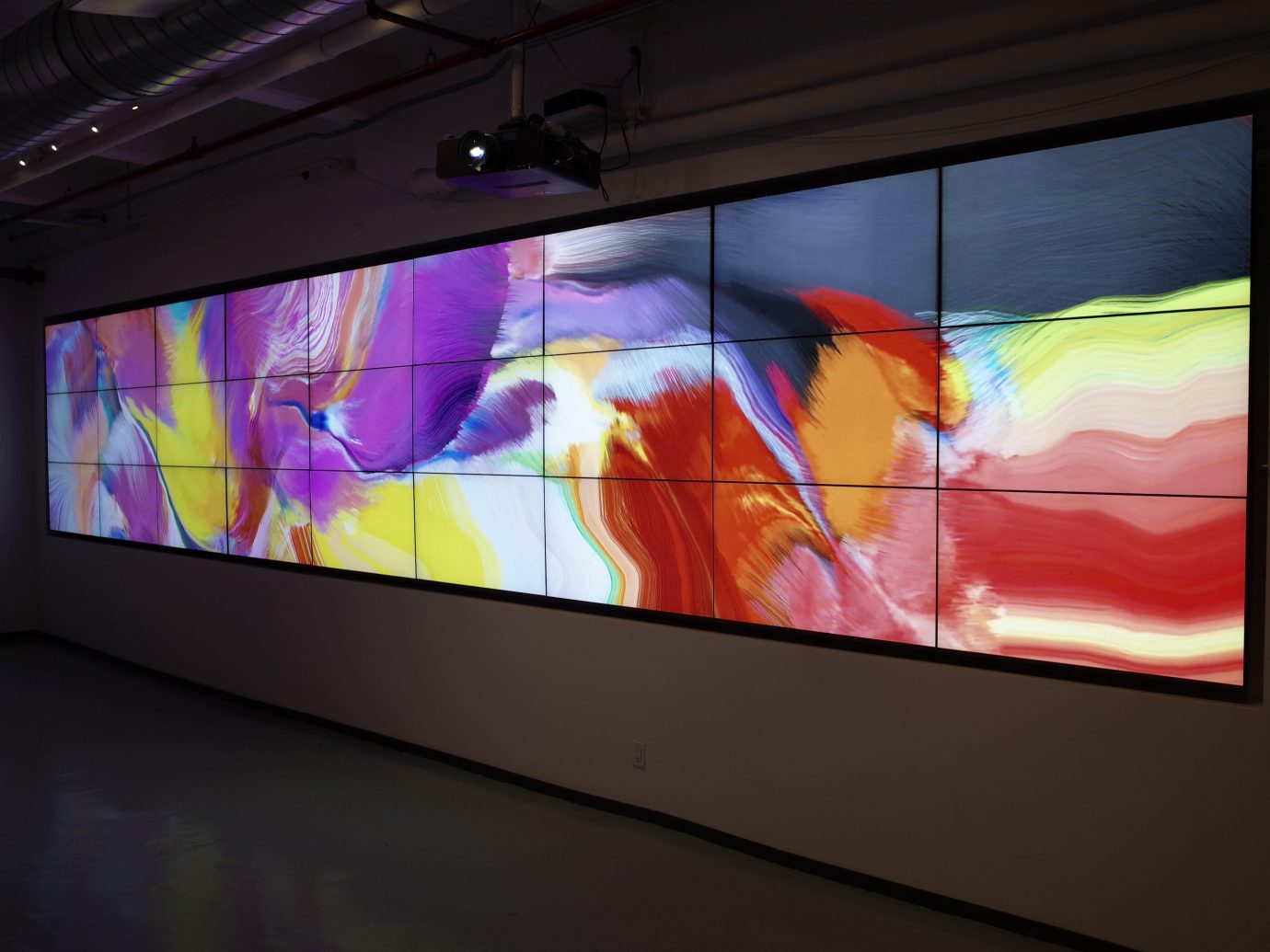 Modern, generative art installation displayed across multiple screens arranged side by side to form a single, large canvas.